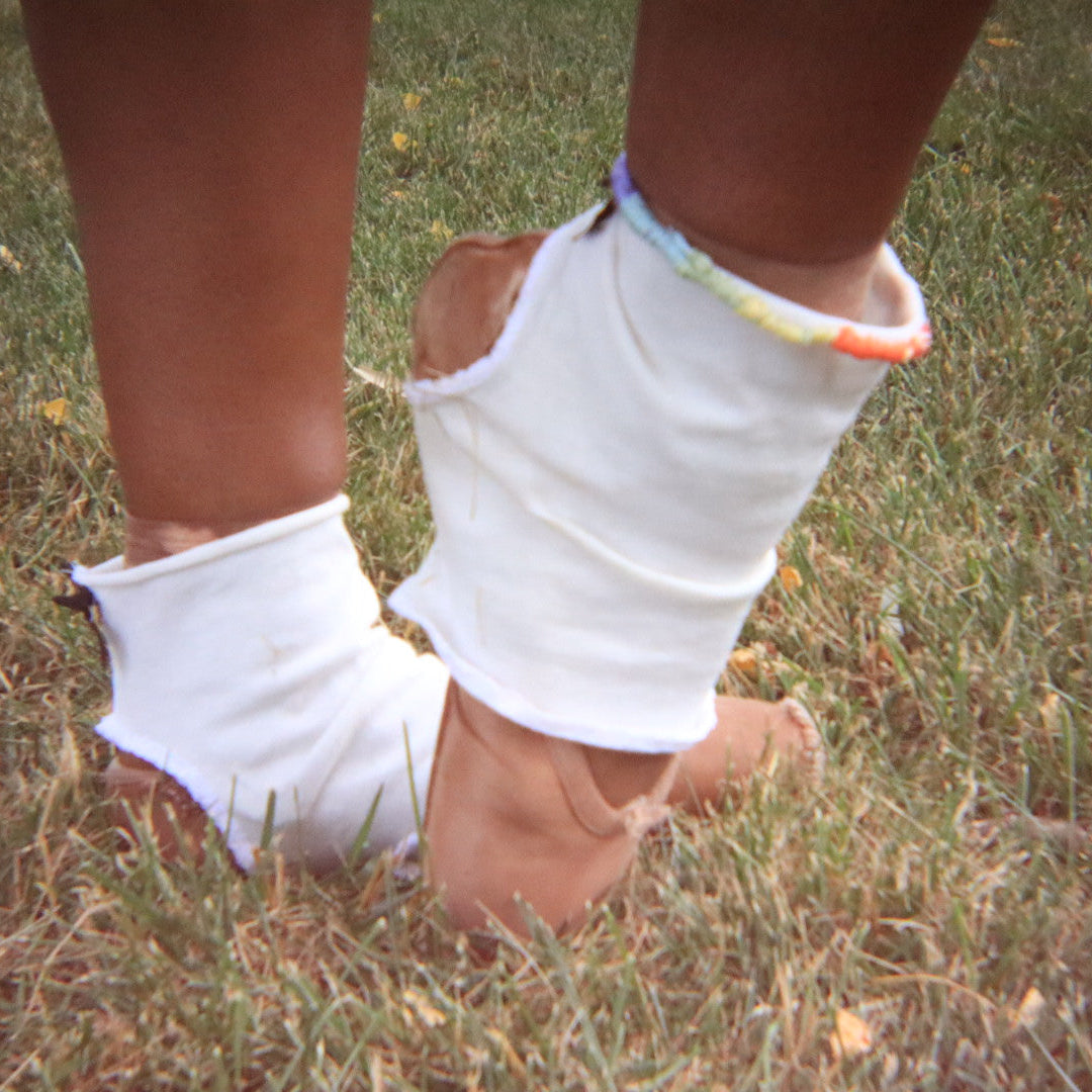 White anklets on feet standing on grass